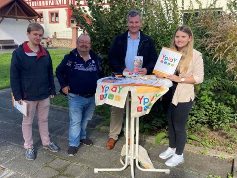 Gruppe Personen stehen vor Hecke an Stehtisc YPLAY Werbung, Glasfaserausbau Ronneburg