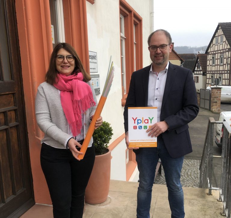 Frau Reichert-Dietzel (Bürgermeisterin Ranstadt) und Peer Kohlstetter (Geschäftsführer Yplay) mit Glasfaser-Leerrohr in der Hand und Beratungsmappe