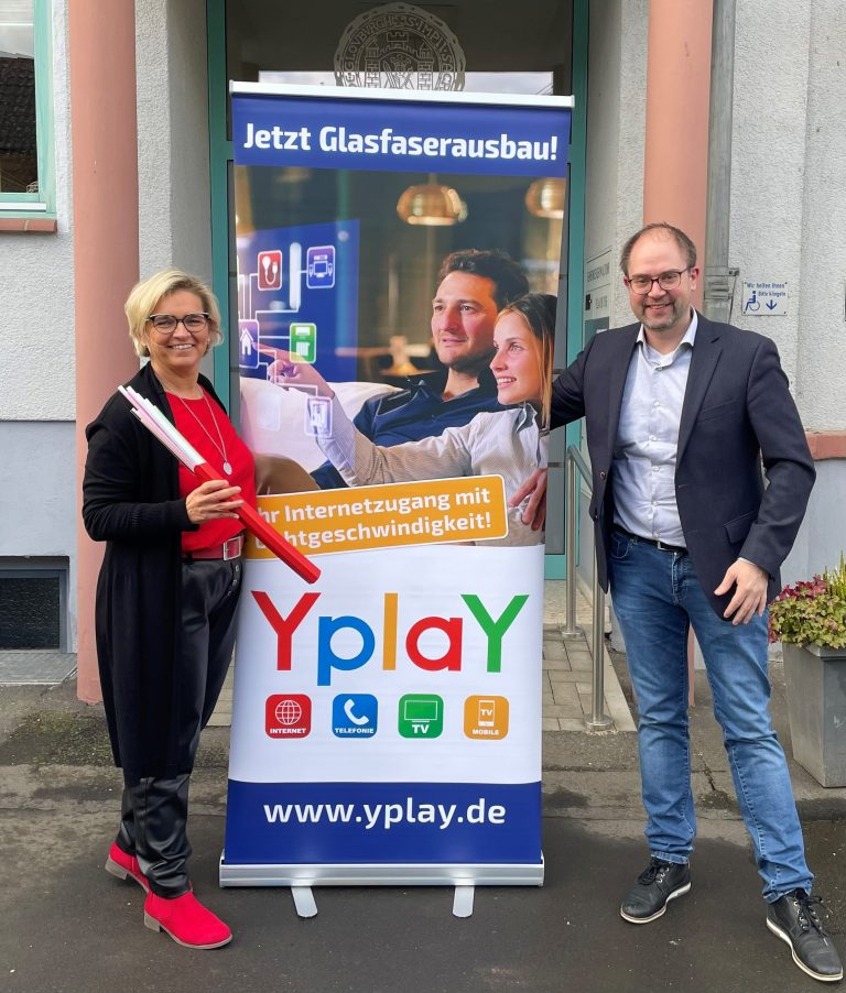Peer Kohlstetter und Henrike Strauch vor Rathaus Glauburg mit großem Yplay Banner