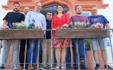 Gruppe von Personen um Geschäftsführer Peer Kohlstetter und Bürgermeisterin Cecilia Reichert stehen vor Geländer mit Blumenkasten nach Gepräch zum Glasfaserausbau in Ranstadt