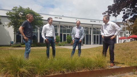 4 Männer stehen auf einer Wiese vor einem Gebäude wegen des Glasfaserausbaus Karben