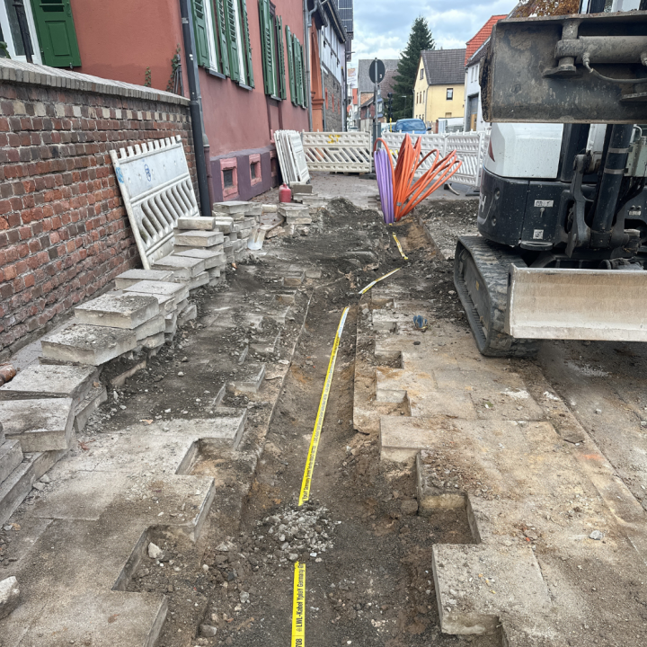 Baustelle in Echzell, welche einen Bagger zeigt und offenen Kanäle für Leehrrohre