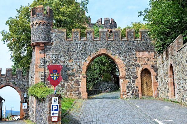 Mittelalterlicher Torbogen und Mauern vor Bäumen in Staufenberg